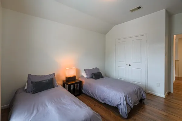 a bedroom with a bed and wooden floor