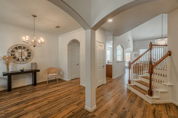 a view of a livingroom with furniture a chandelier wooden floor and a chandelier