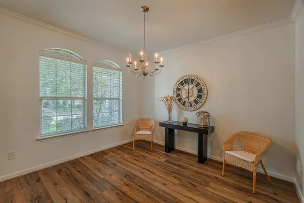 a dining room with furniture a chandelier and wooden floor