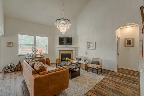 a living room with furniture chandelier and a fireplace
