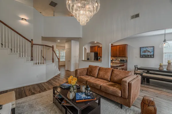 a living room with furniture and a chandelier