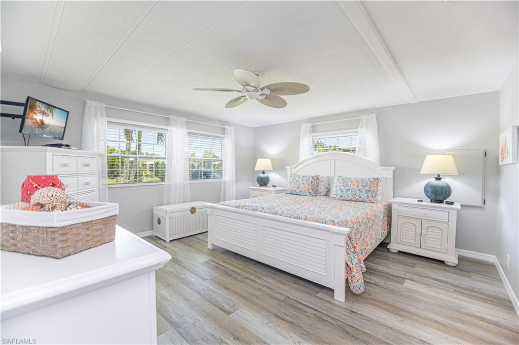 4 Chateau Way Naples, FL 34112 - Photo 11 of 21 a spacious bedroom with two beds and a chandelier