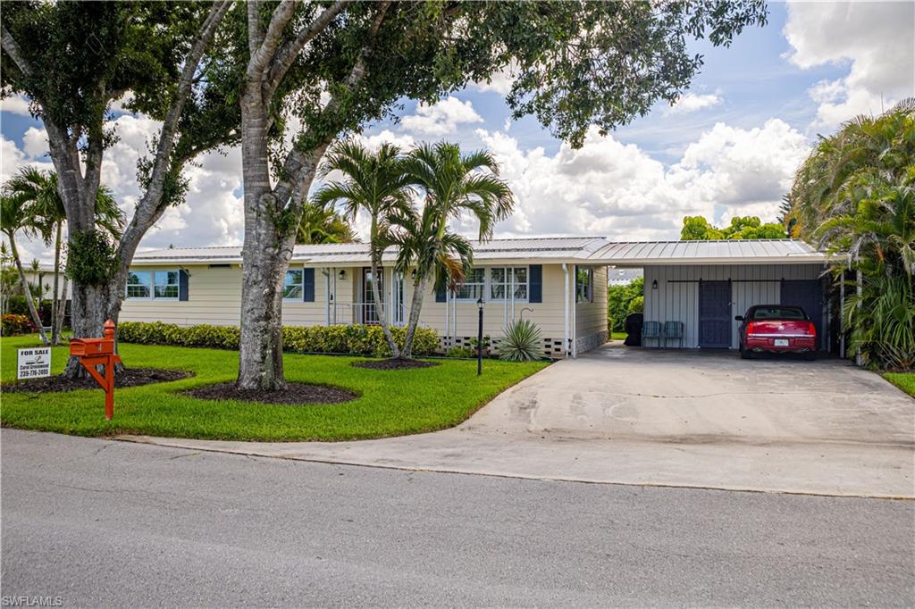 4 Chateau Way Naples, FL 34112 - Photo 2 of 21 a front view of a house with a yard and potted plants