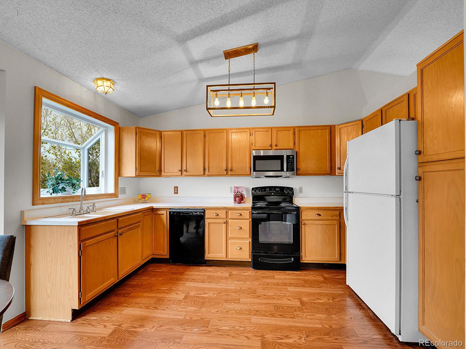 6343 Laguna Circle Highlands Ranch, CO 80130 - Photo 15 of 43 a large kitchen with stainless steel appliances granite countertop a stove a sink and a refrigerator