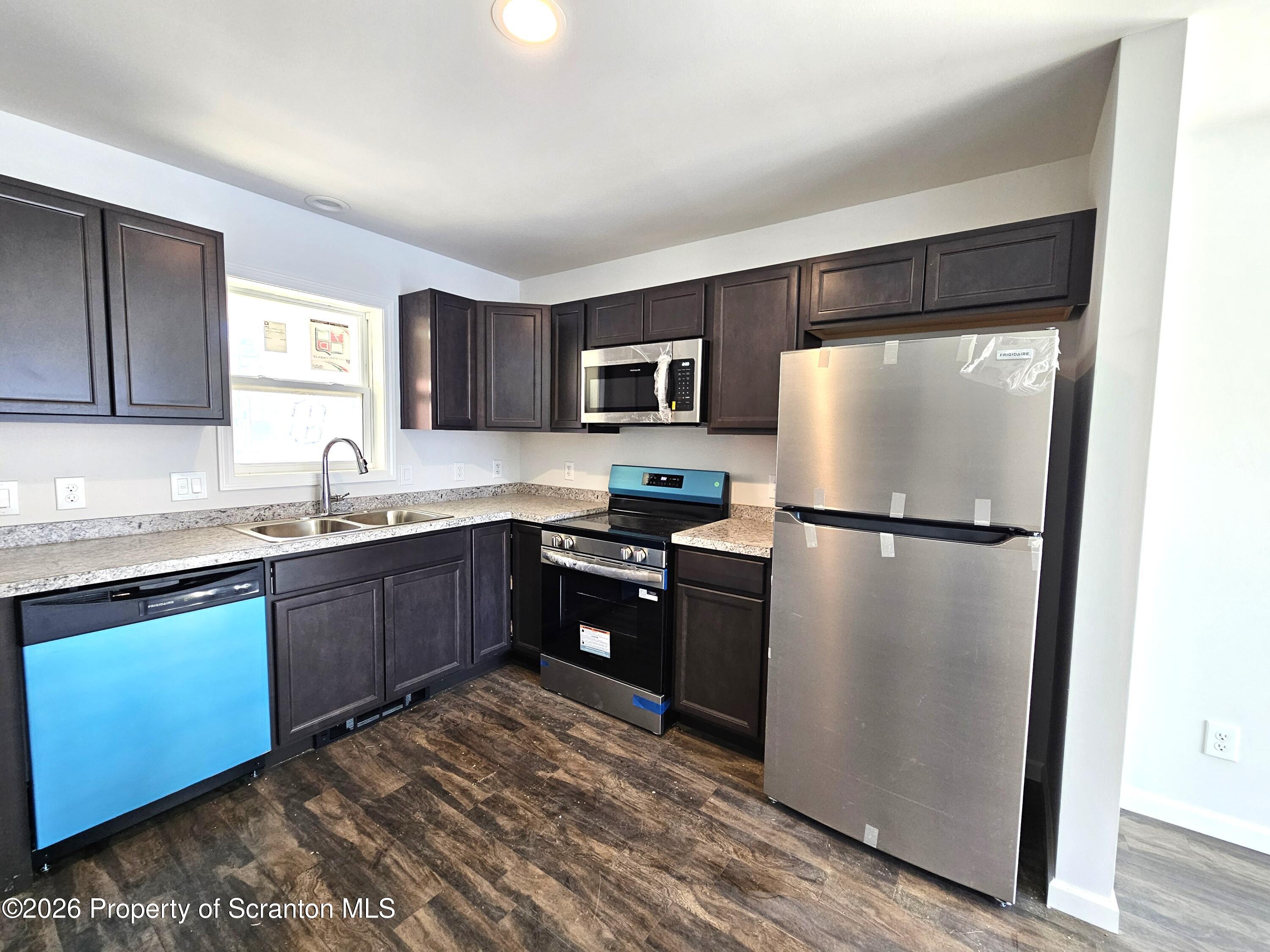 609 East Gibson Street, Unit 1 Scranton, PA 18510 - Photo 3 of 9 a kitchen with a refrigerator sink and wooden cabinets