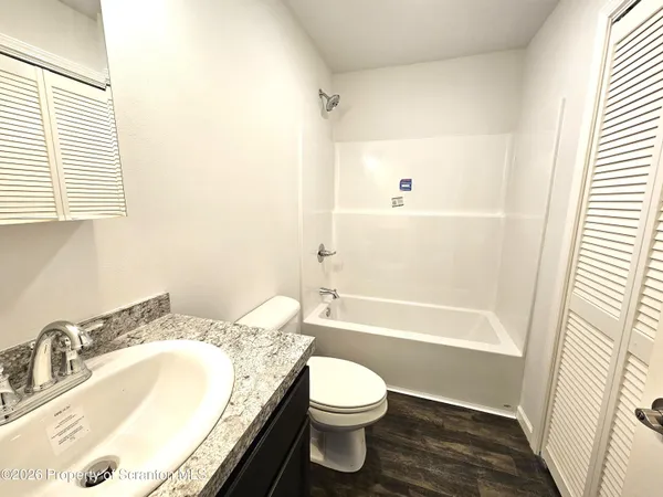 a bathroom with a granite countertop sink toilet and shower
