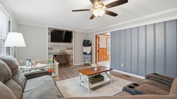 a living room with furniture a flat screen tv and a fireplace