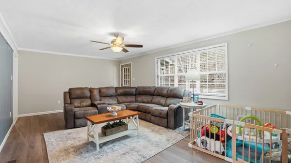 a living room with furniture a baby crib and a chandelier