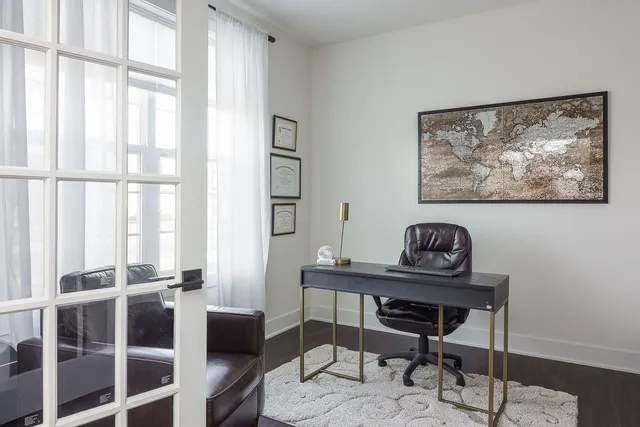 a view of a workspace with furniture and a window