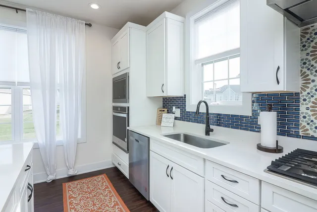 a kitchen with stainless steel appliances granite countertop a sink stove and cabinets