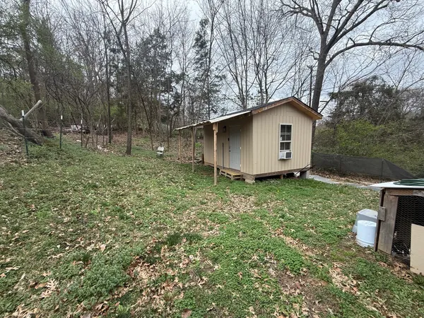 a house is sitting in middle of the green field