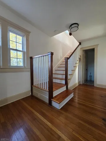 a view of a livingroom with wooden floor and stairs