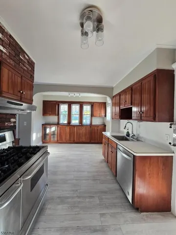 a large kitchen with stainless steel appliances granite countertop a stove and a sink