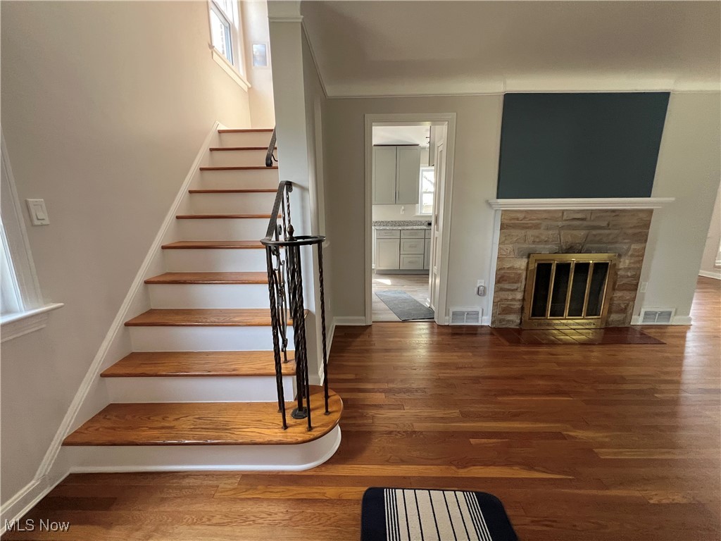 4236 Ridgeview Road Cleveland, OH 44144 - Photo 5 of 22 Staircase featuring a stone fireplace and hardwood floor.