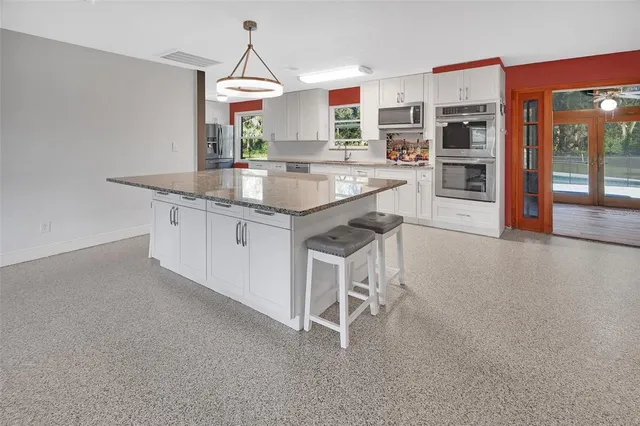 a view of an empty room with window and cabinet