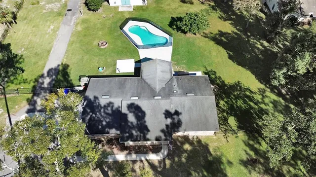 an aerial view of a house with a yard and trees