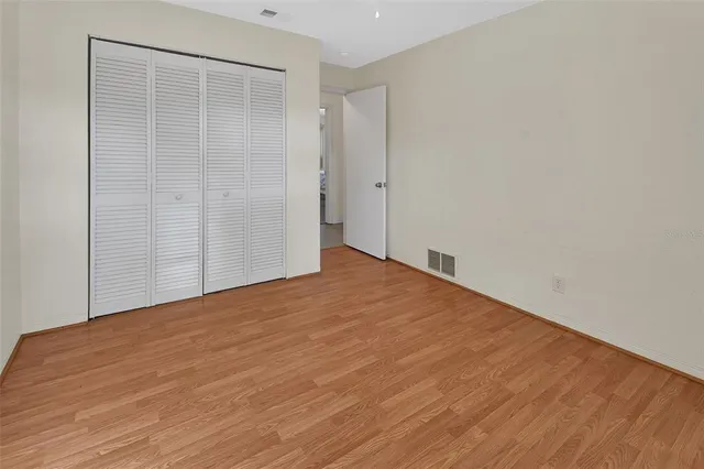 a view of a swimming pool with a patio and wooden fence