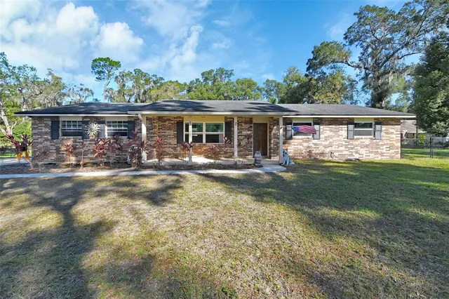 a view of house with backyard outdoor seating and garden