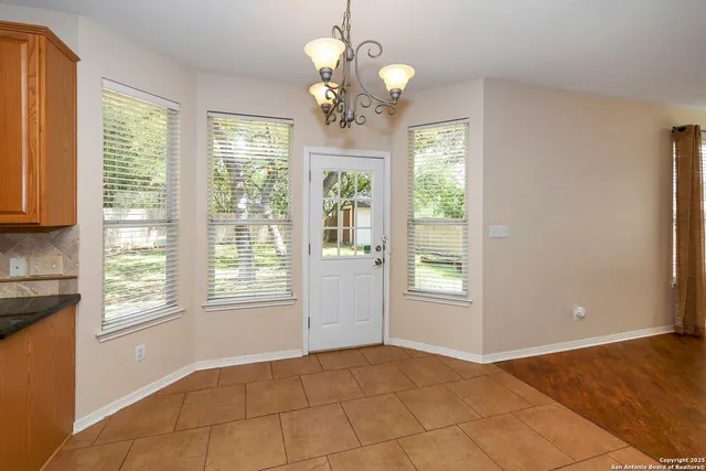 a kitchen with stainless steel appliances granite countertop a refrigerator oven stove a sink a dining table and chairs with wooden floor