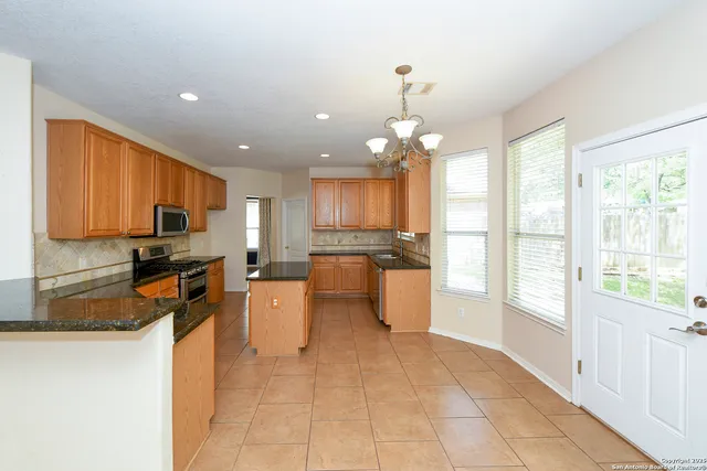 a view of an empty room with a window and fireplace