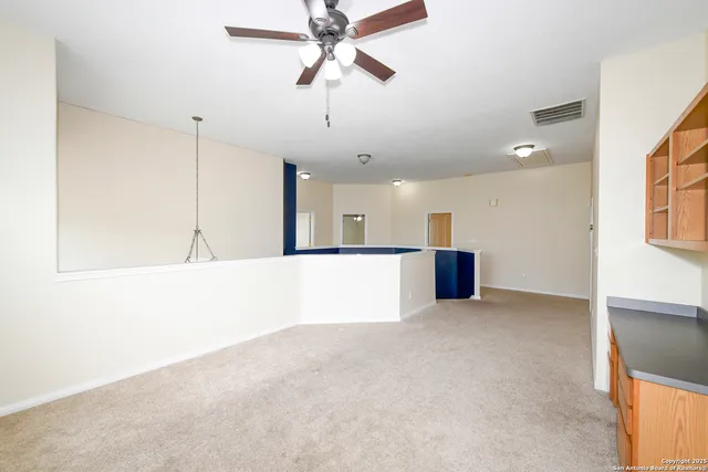 an empty room with a window and a ceiling fan