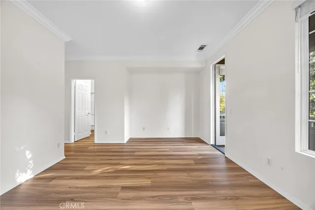 a view of a room with wooden floor and windows
