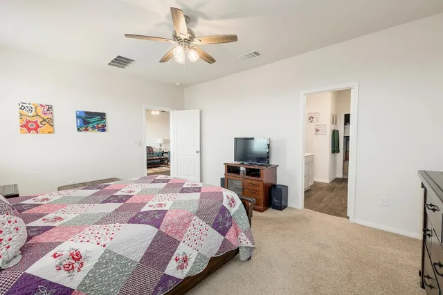 a bedroom with a bed and a flat screen tv