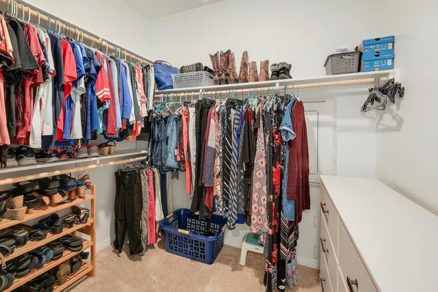 a view of walk in closet with clothes and shoes