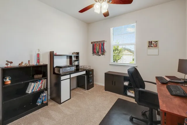 a view of a workspace with furniture and a window