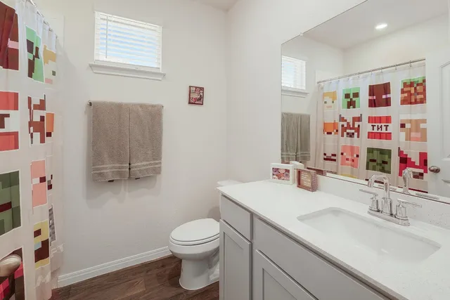 a bathroom with a sink vanity mirror and toilet