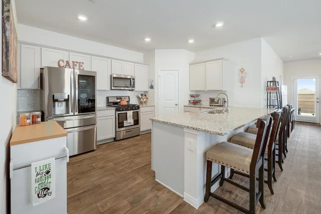 a kitchen with white cabinets and stainless steel appliances