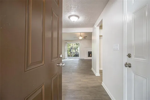 a view of a hallway with wooden floor and closet area