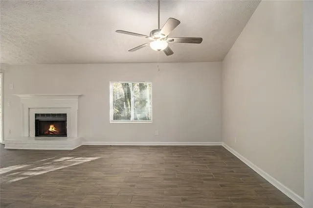 an empty room with windows and fireplace