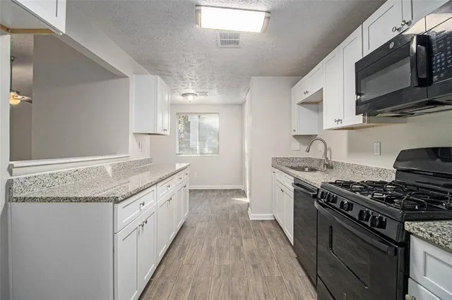 a kitchen with stainless steel appliances granite countertop a stove and a microwave