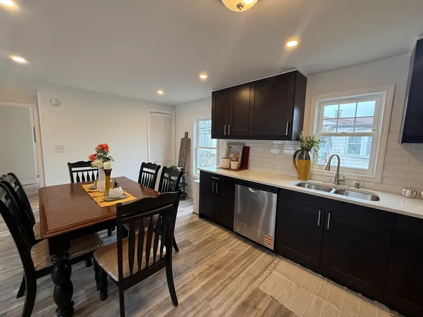 a kitchen with a dining table chairs and sink
