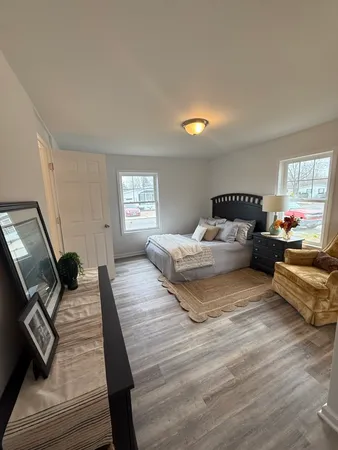 a bedroom with a bed and wooden floor