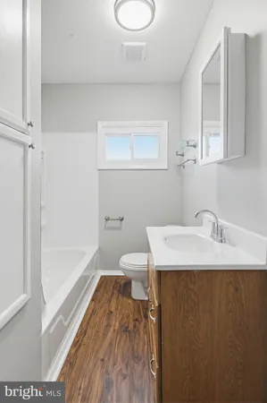 an empty room with wooden floor and ceiling fan