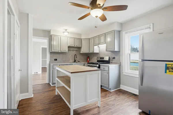 a kitchen with a refrigerator a sink and dishwasher with wooden floor