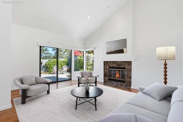 a living room with furniture a fireplace and a large window
