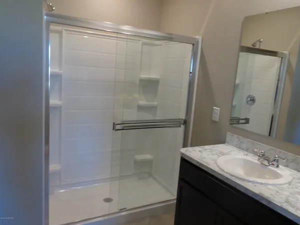 a bathroom with a granite countertop sink mirror and shower