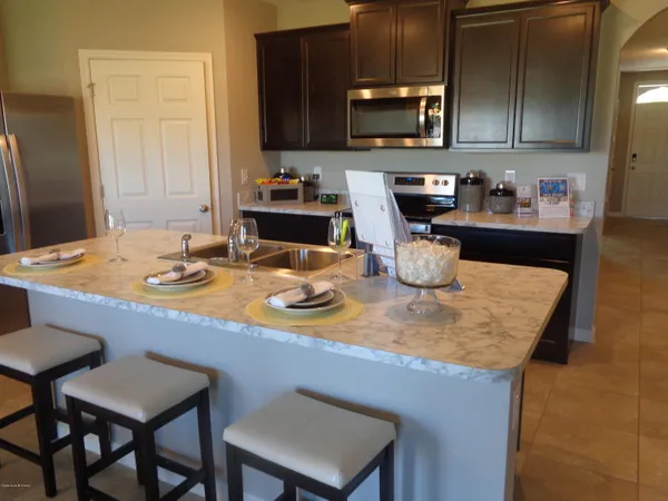 a kitchen with a sink a stove and chairs