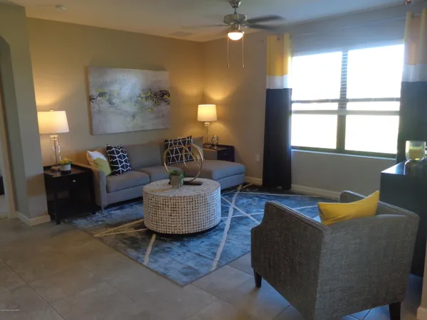a living room with fireplace furniture and a large window