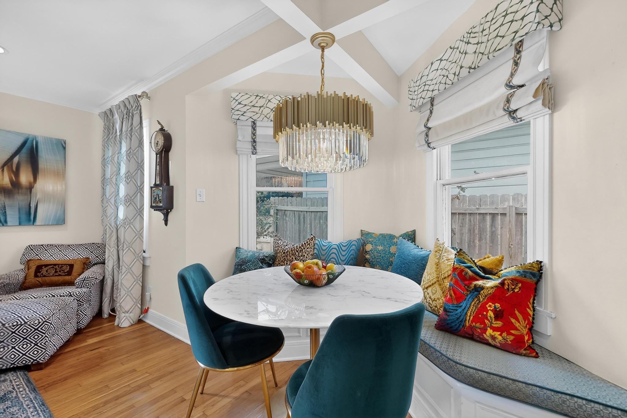 1906 Collier Street Austin, TX 78704 - Photo 11 of 40 This home offers three distinct dining spaces, and this one is especially well-placed just off the kitchen. The charming pop-out provides plenty of room to gather and enjoy a meal, highlighted by an elegant chandelier and finished with custom seat cushions and pillows that elevate the space both in comfort and style.