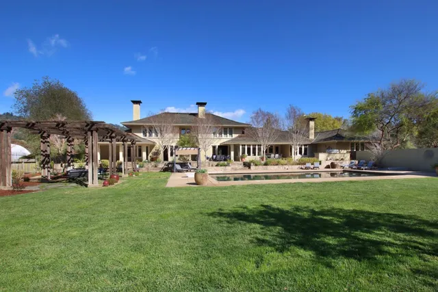a front view of a house with swimming pool table and chairs