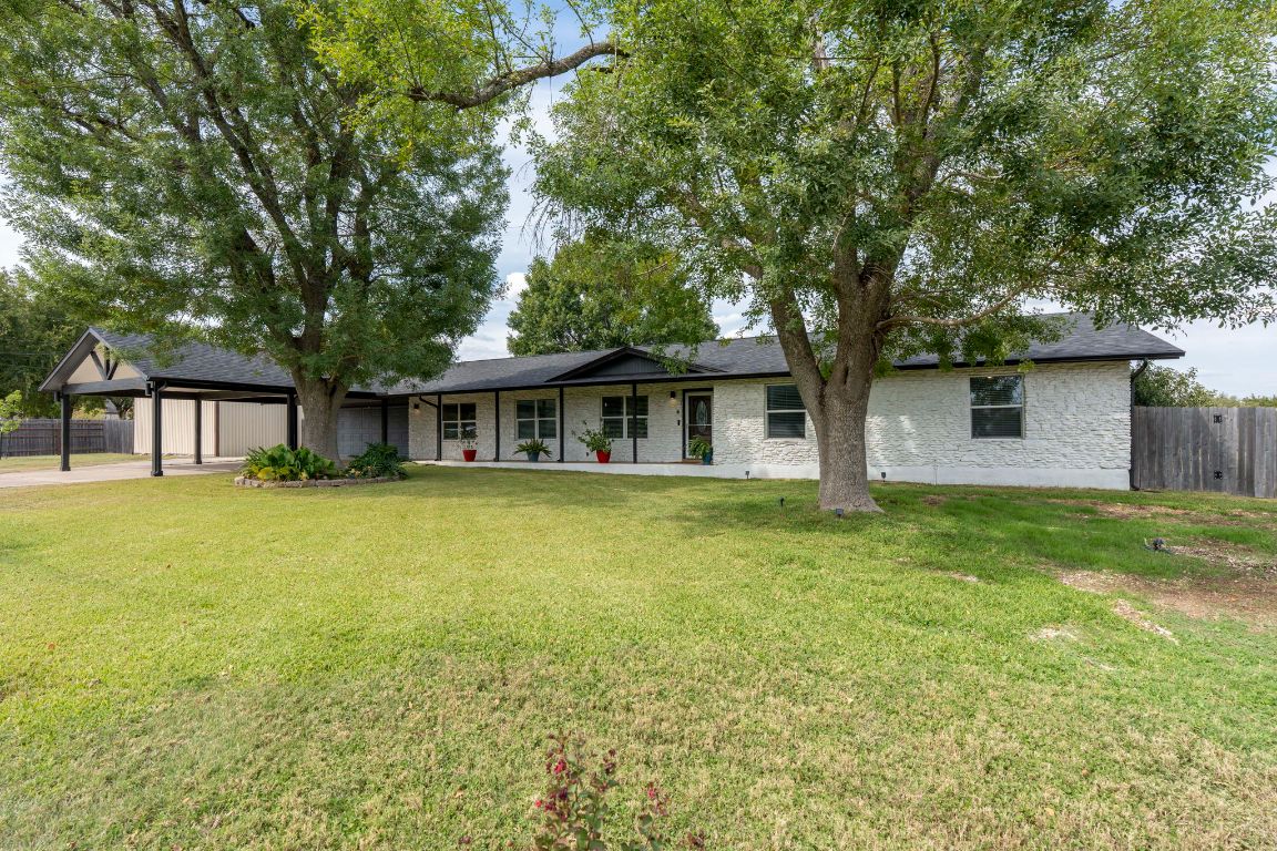 Ranch-style home with concrete driveway, an attached garage, brick siding, and roof with shingles