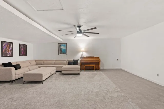 a living room with furniture and a ceiling fan