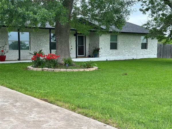 a front view of a house with a garden and plants