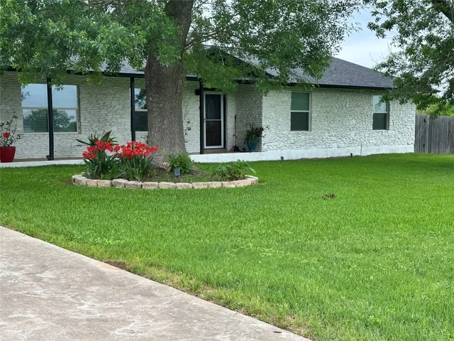 a front view of a house with a garden and plants