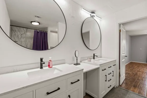 a bathroom with a double vanity sink and a mirror