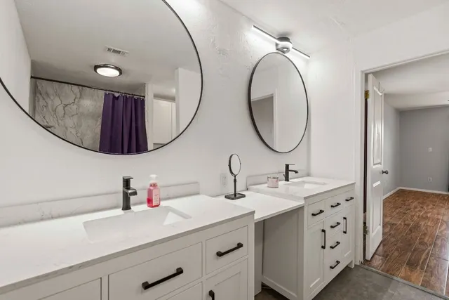 a bathroom with a double vanity sink and a mirror